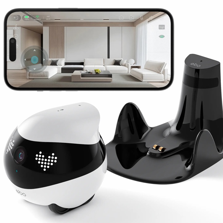 Round black-and-white EBO Air 2 home robot beside its black cat-ear charging dock, with a smartphone above showing the app's live camera view.