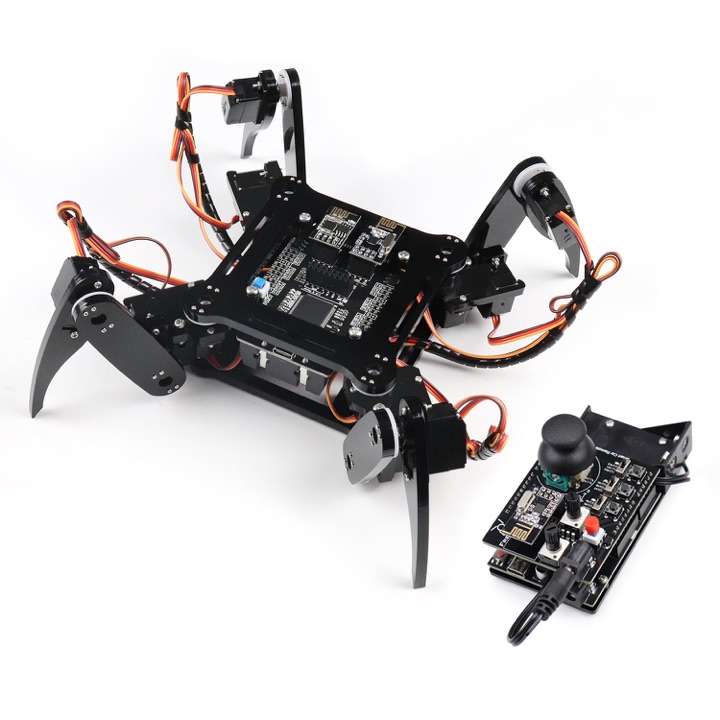 Black acrylic four-legged spider robot kit with exposed circuit boards, standing next to its joystick remote control on a white background.