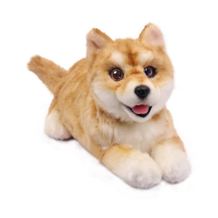 Cream-and-ginger metaDog robotic puppy lying down with its tongue out and tail raised, photographed on a white background.